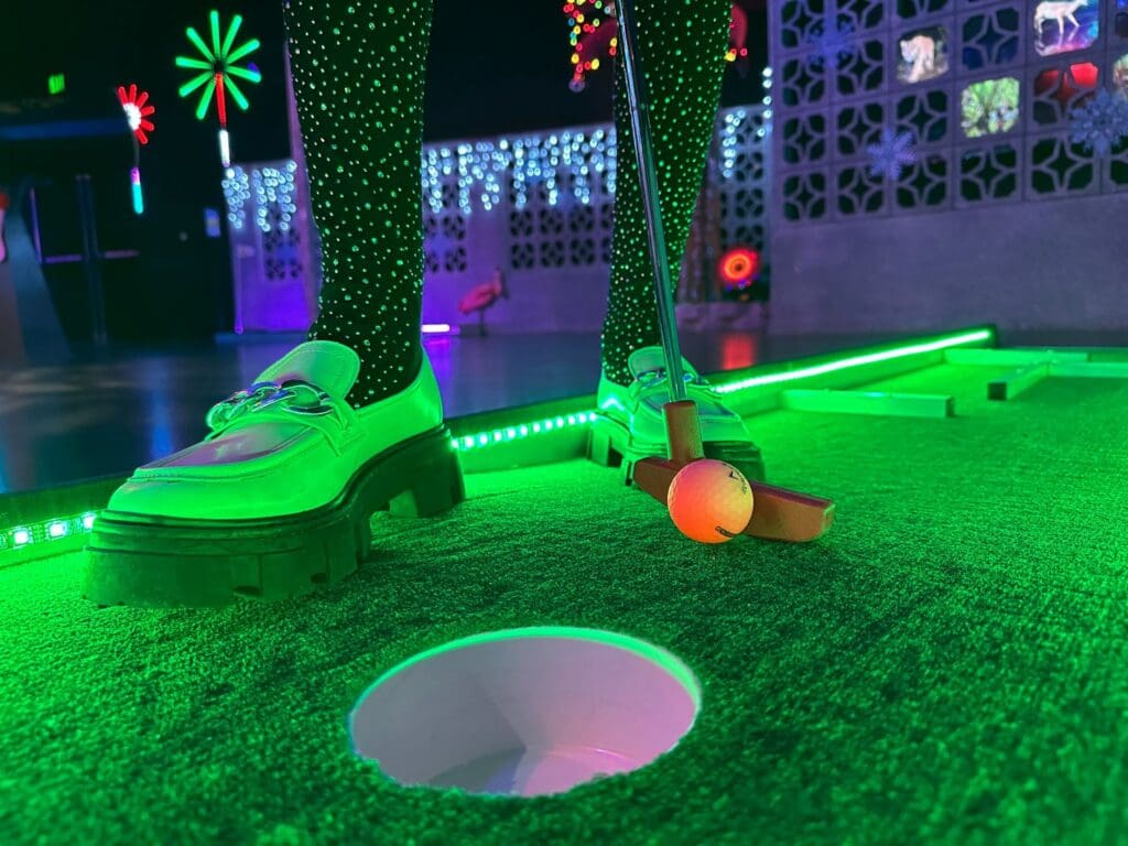 an image of a fun dressed woman playing minigolf